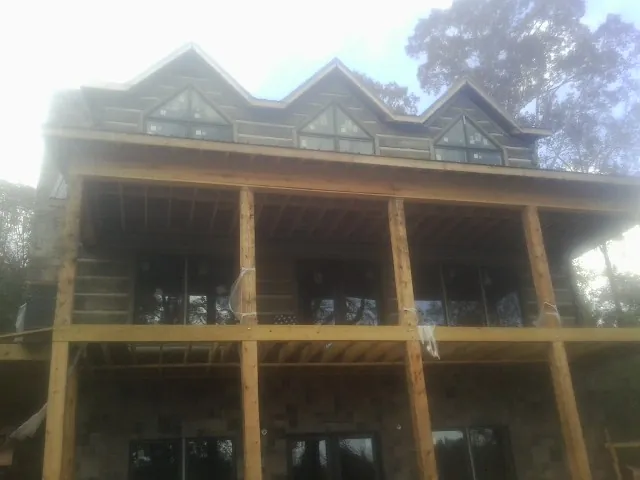 Dormers and porch framing on a large log home under construction — Roof Coating work by our crew in Allensville