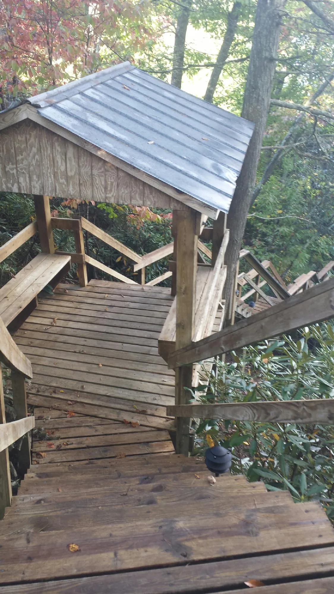 Metal roofed shelter over wooden steps on a wooded walkway — Skylight Repair & Installation work by our crew in Allensville
