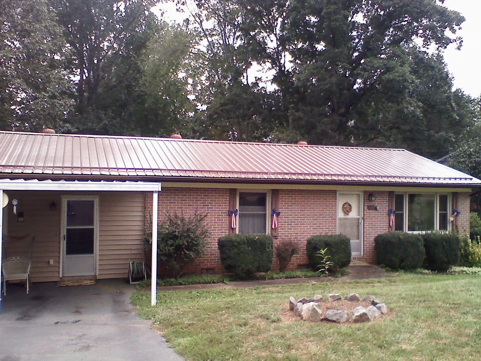 Bronze metal roof and carport on a brick ranch home — Roof Repair work by our crew in Allensville